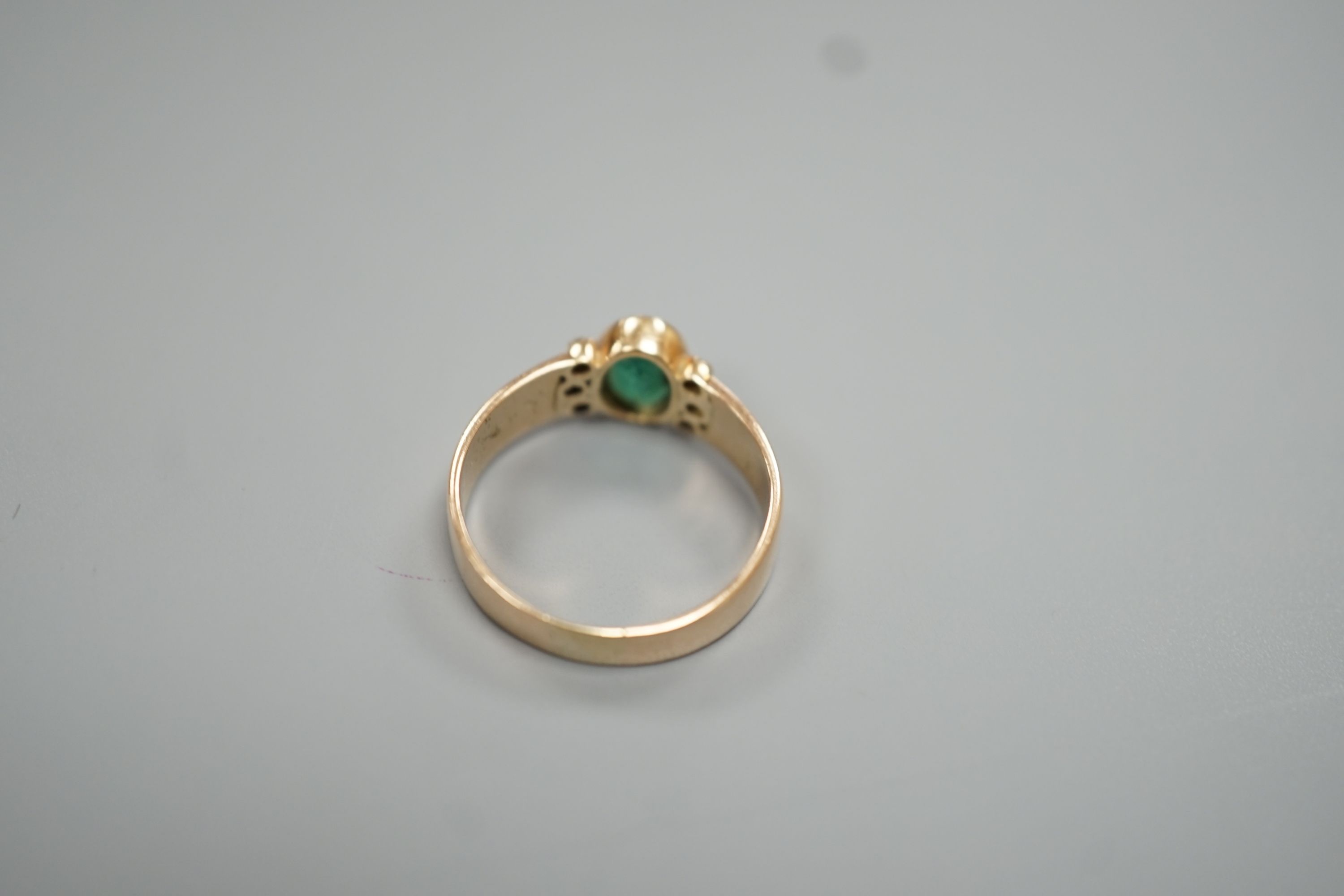 A yellow metal, oval cut emerald and six stone diamond chip set ring, size O, gross weight 3 grams.